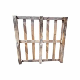 Gebruikte houten pallet met open dek en 10 verticale latten, staand op zijn kant in een witte studio-omgeving.