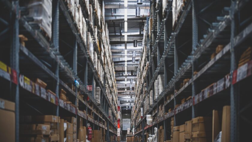 Magazijn met hoge stellingen vol dozen en goederen voor opslag en distributie